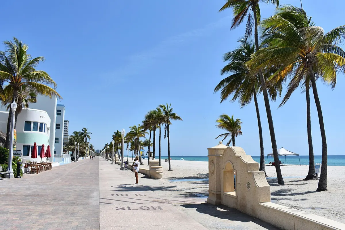 The Hollywood Beach Broadwalk with palms, low buildings and the beach alongside